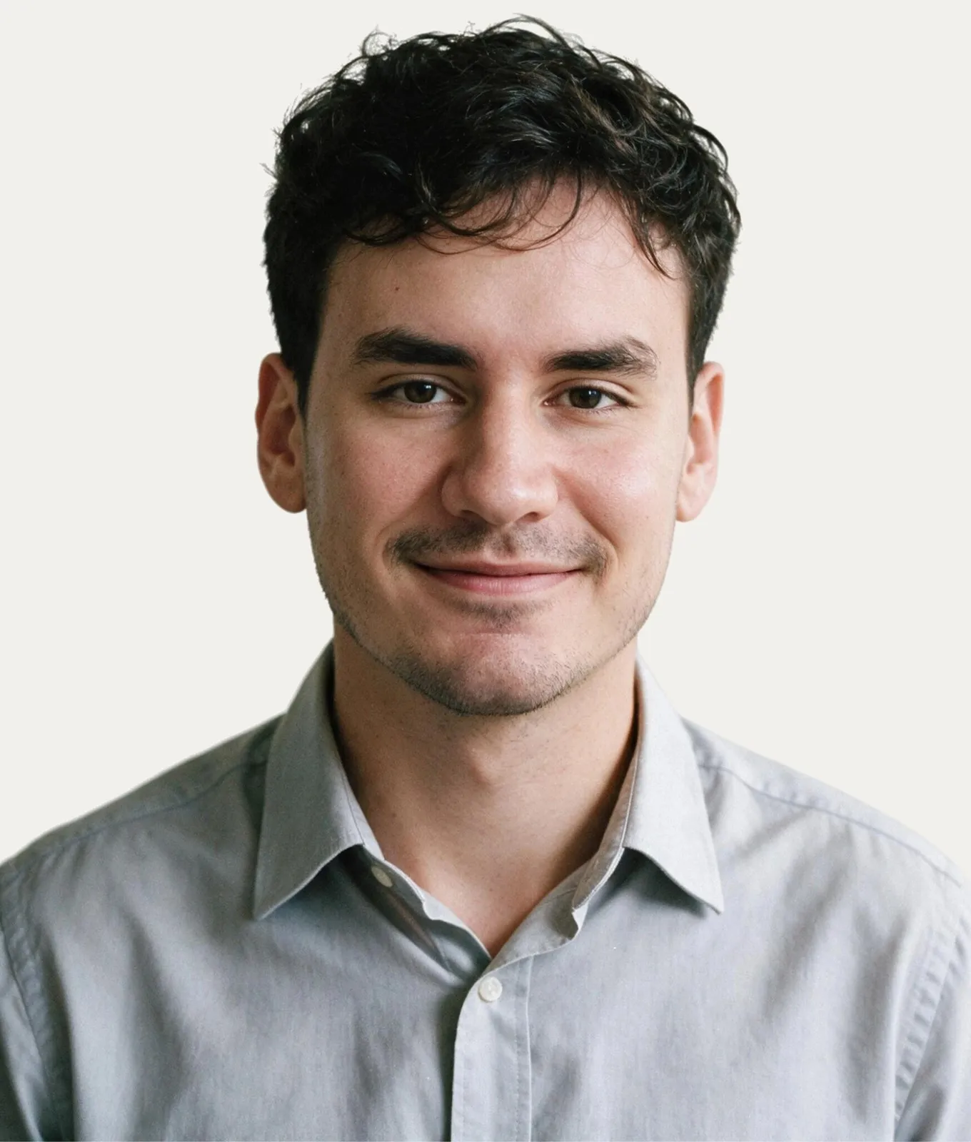 Heron Souki smiling, in a light grey button-up shirt